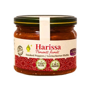 Lasipurkki savustettua paprikaa sisältävää harissaa, itämaista mausteista chilikastiketta, lähikuva valkoisella taustalla.