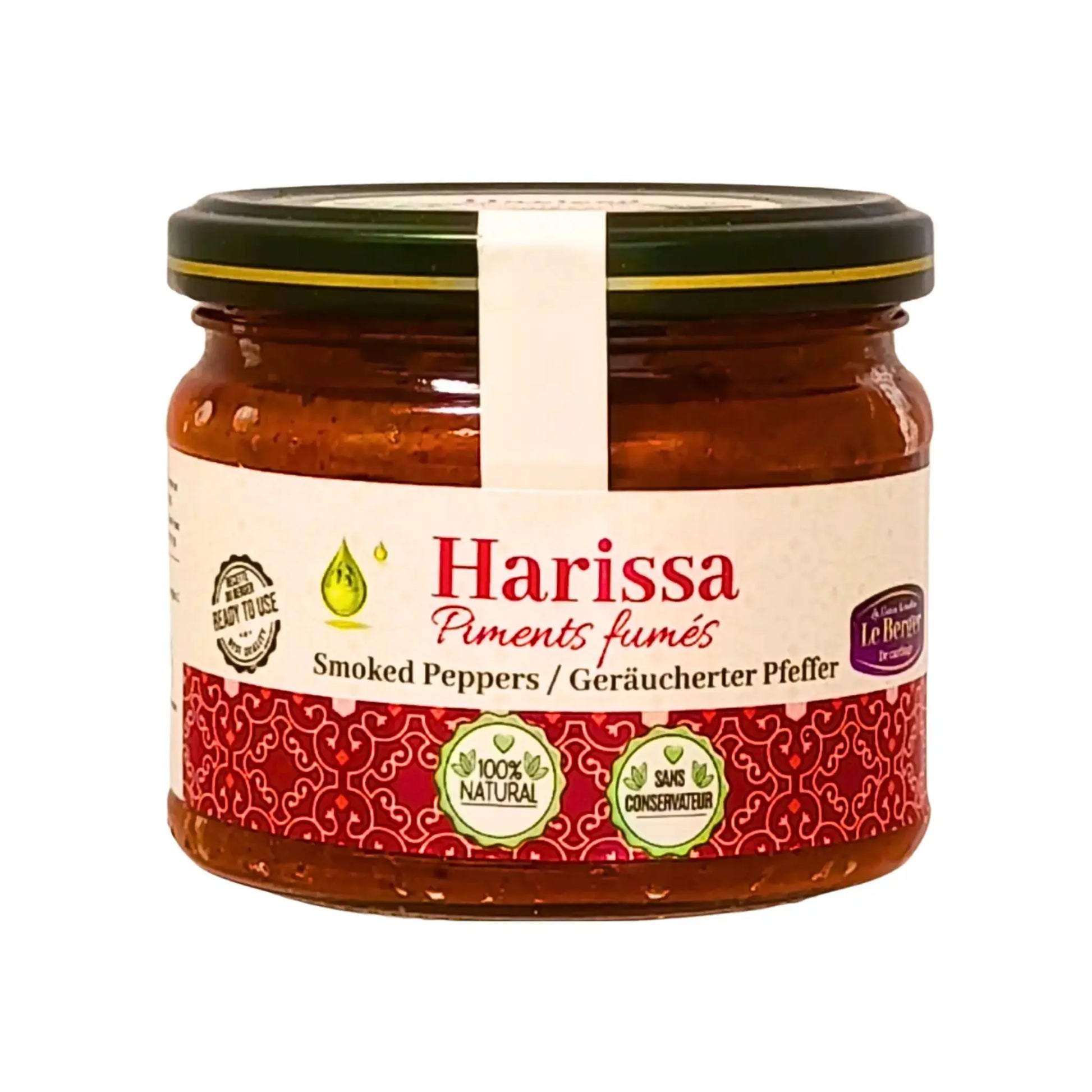 Lasipurkki savustettua paprikaa sisältävää harissaa, itämaista mausteista chilikastiketta, lähikuva valkoisella taustalla.