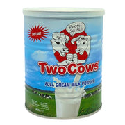 Purkki, jossa on Two Cows -maitojauhetta 400 g, sininen tausta, lehmäkuvat, vihreä niitty.